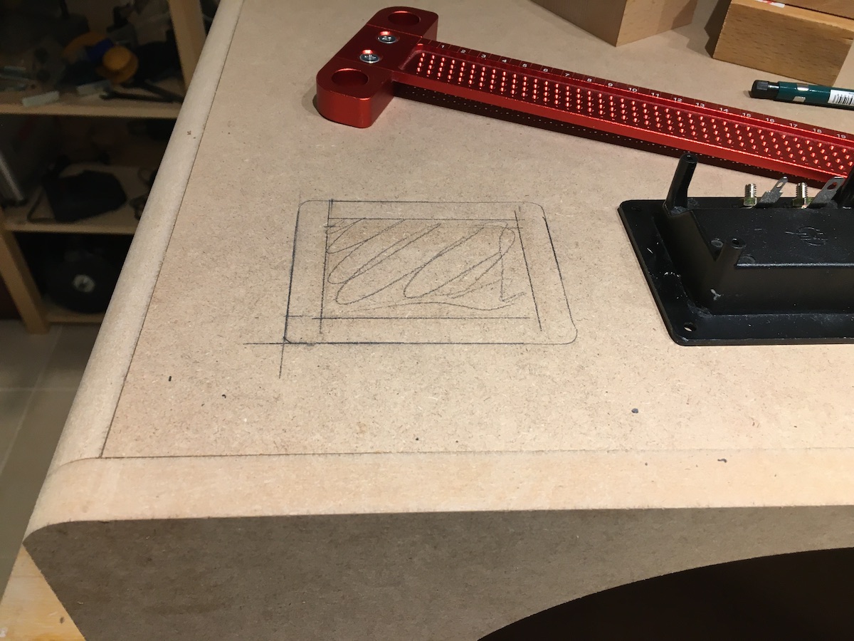 Marking the cutout for a speaker terminal cup.